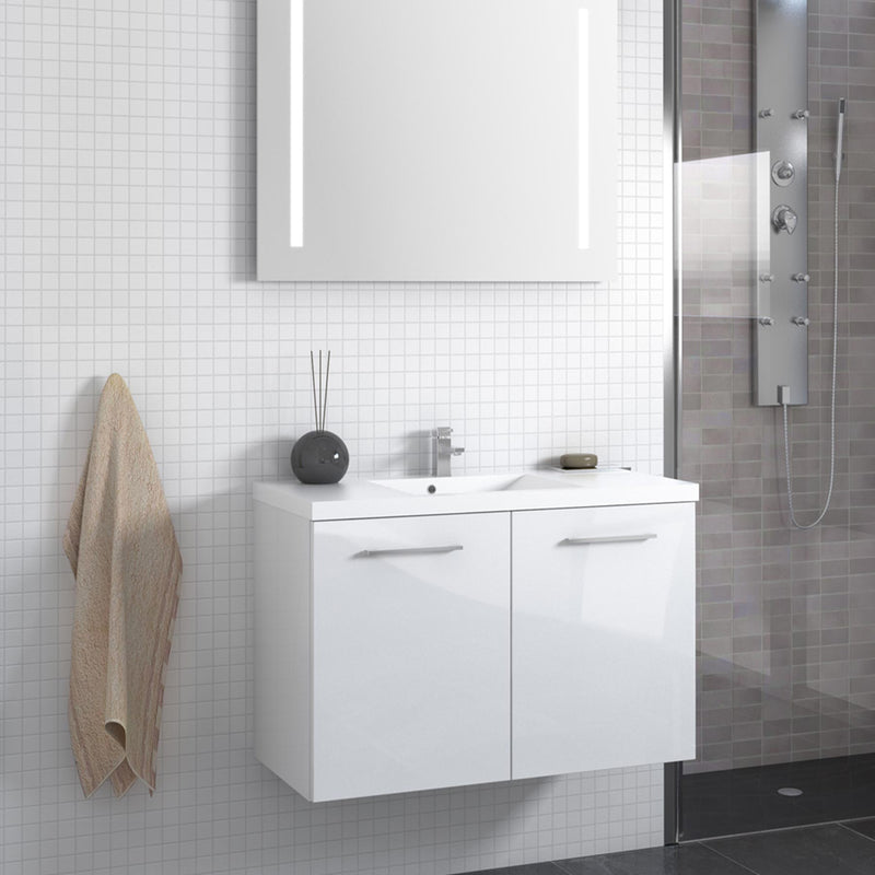 White wall mounted vanity unit with basin and two doors on a bathroom wall with a bathroom mirror above and a walking shower on the side