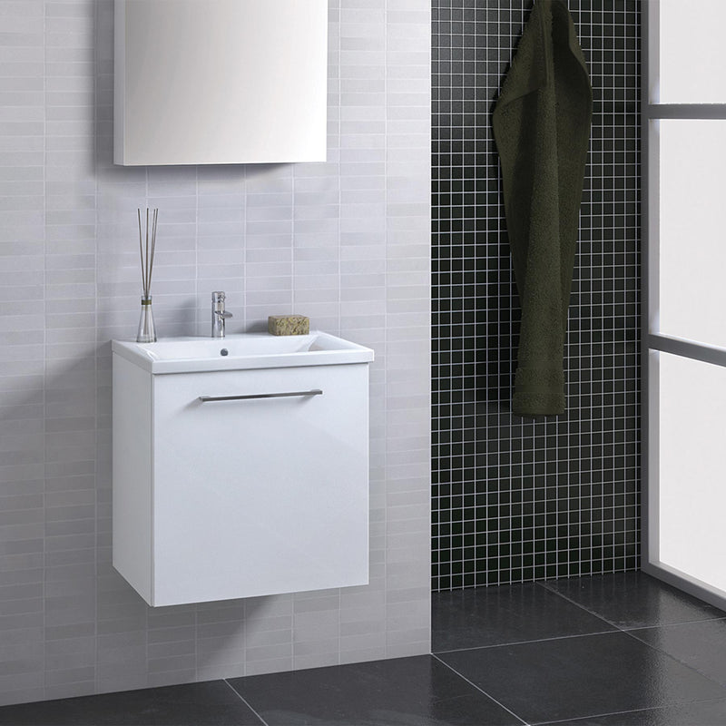 White bathroom wall-mounted vanity unit with basin and single door installed on a white bathroom wall and mirror above the unit 
